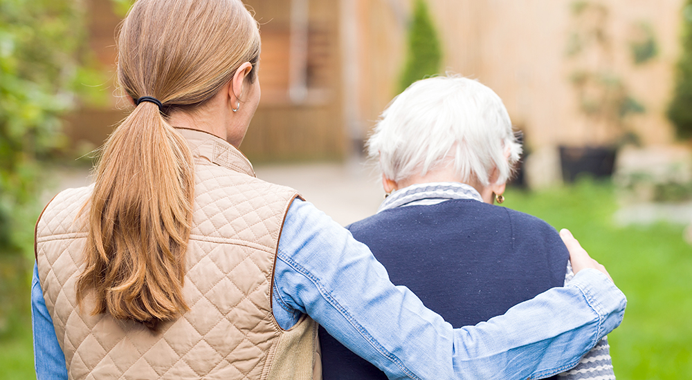 Woman assisting elderly woman walking