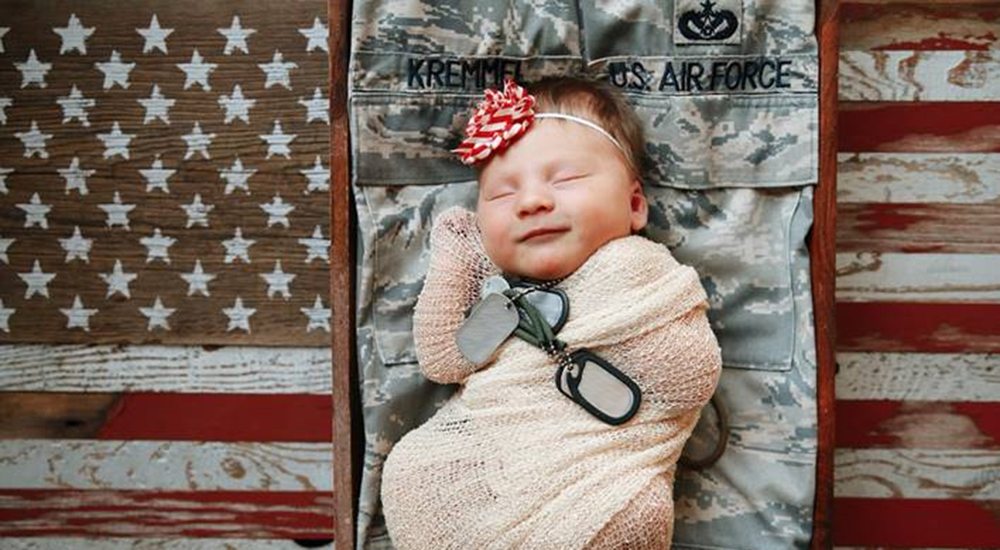 Baby with dog tags sleeping on uniform in vitro