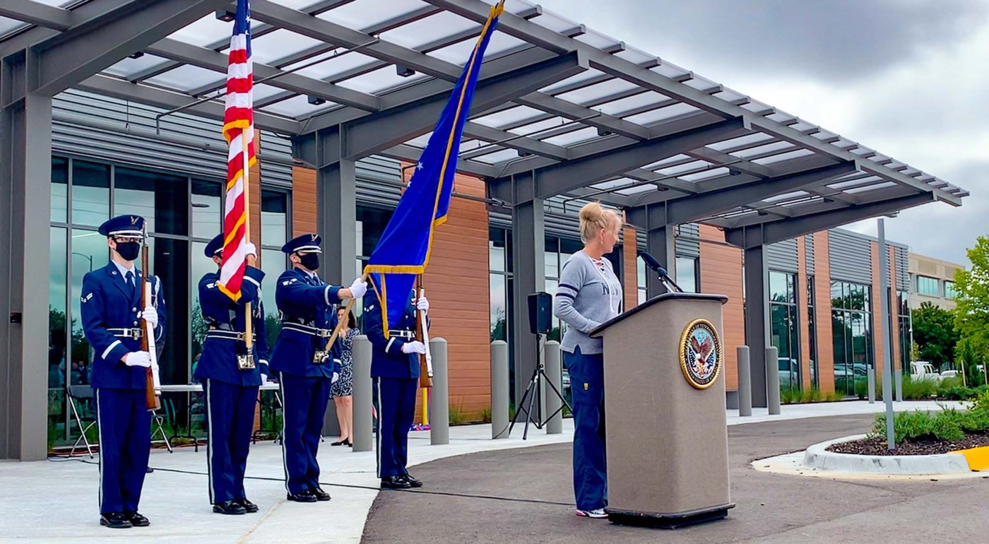 Flag color guard behind woman at podium at opening of Kansas City VA clinic