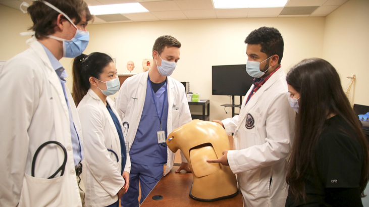 Doctor teaches four medical students