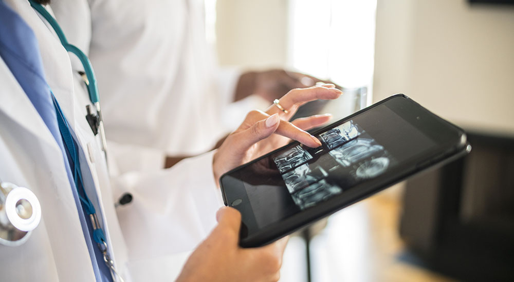 A Telestroke health care provider looks at clinical images on a tablet