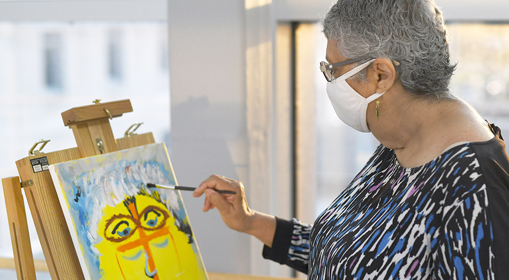 Female Veteran, wearing mask, painting