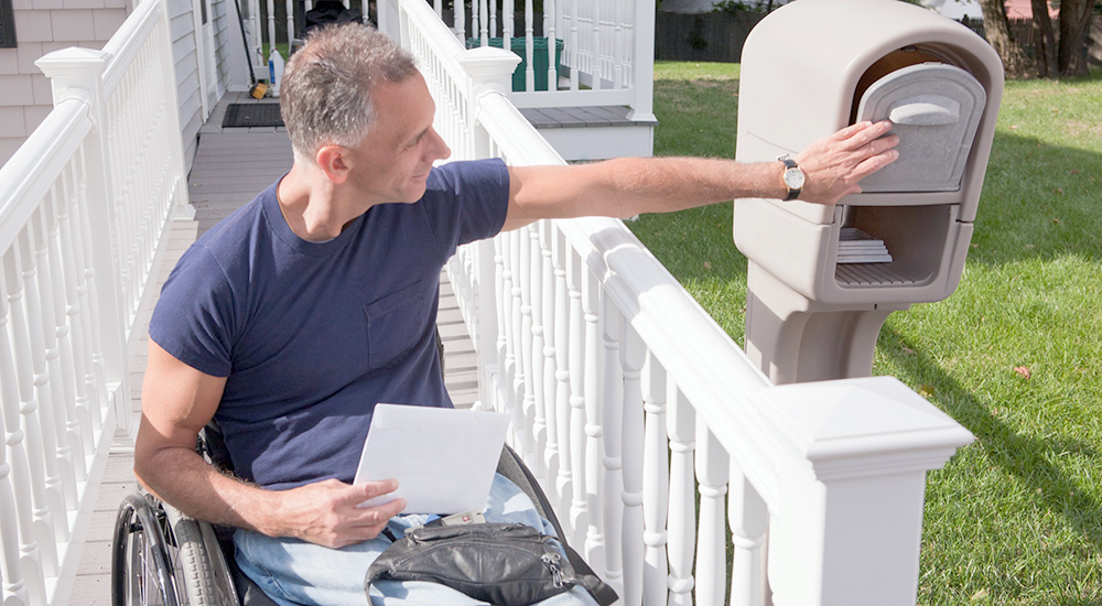 Man in wheelchair checks mail prosthetics