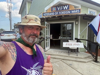 Veteran gives thumbs up outside VFW that provided Hurricane Ida assistance.