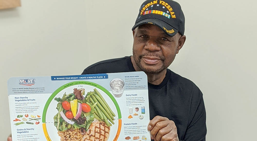 MOVE! program graduate holds healthy food chart