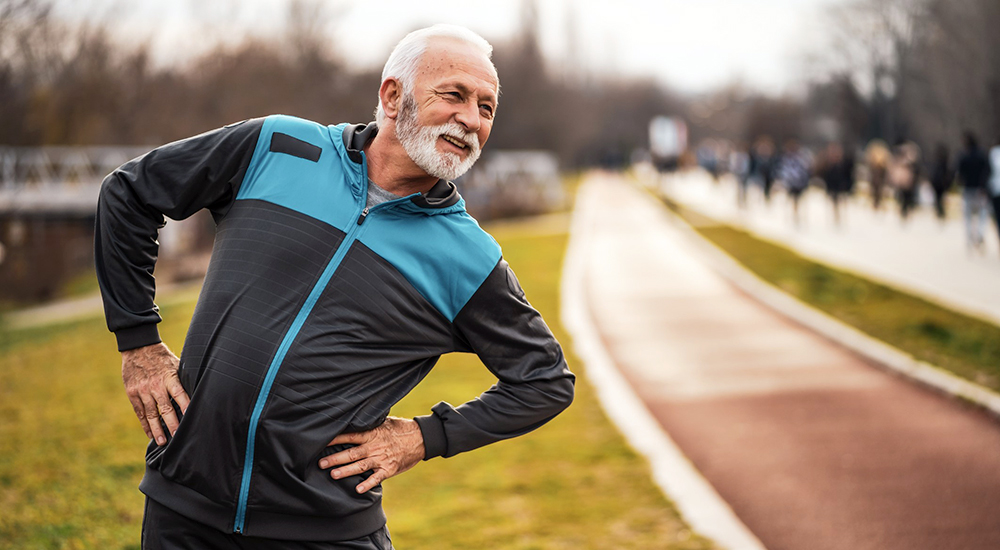 Elderly man doing hip stretches