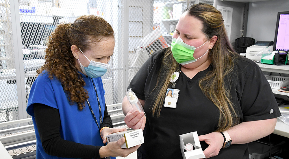 Two pharmacists discuss instructions and equipment