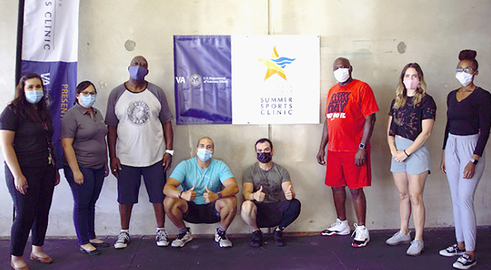 Eight people in a gym wearing masks