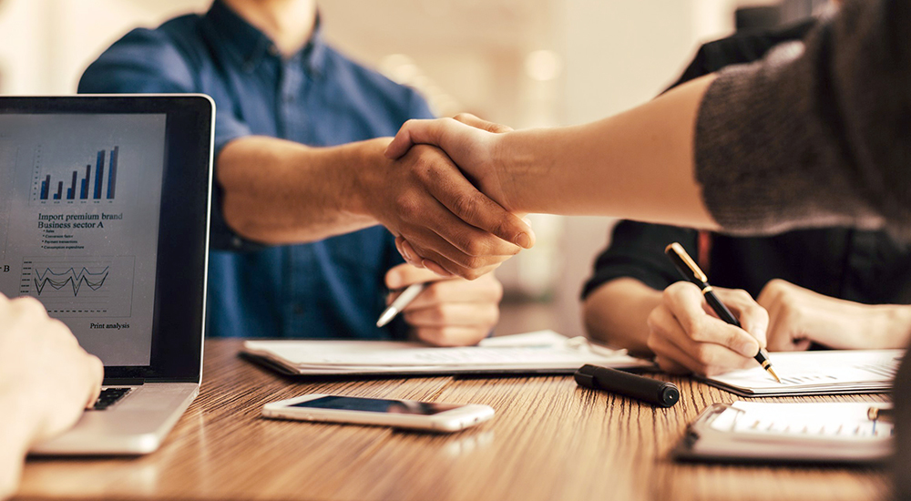 People shaking hands across a table