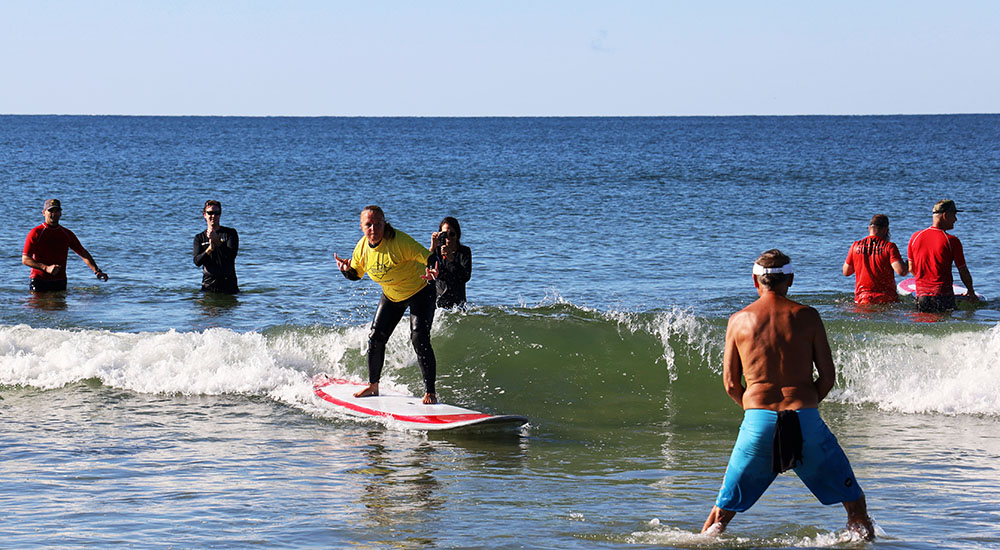 A Veteran riding surfboard in low surf