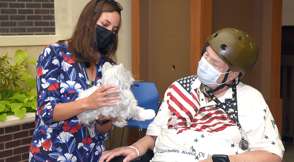 A VA psychologist gives an elderly Veteran a robotic pet