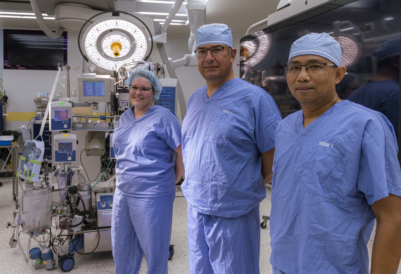 (From left) Drs. Lauren Kennedy-Metz and Marco Zenati and chief perfusionist Rithy Srey stand near a heart-lung machine in an operating room at the West Roxbury VA in Massachusetts. The team is studying how artificial intelligence can help perfusionists optimize use of the machines during cardiac surgery.