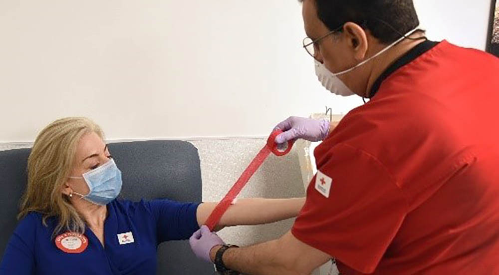 Technician prepares a woman to donate blood