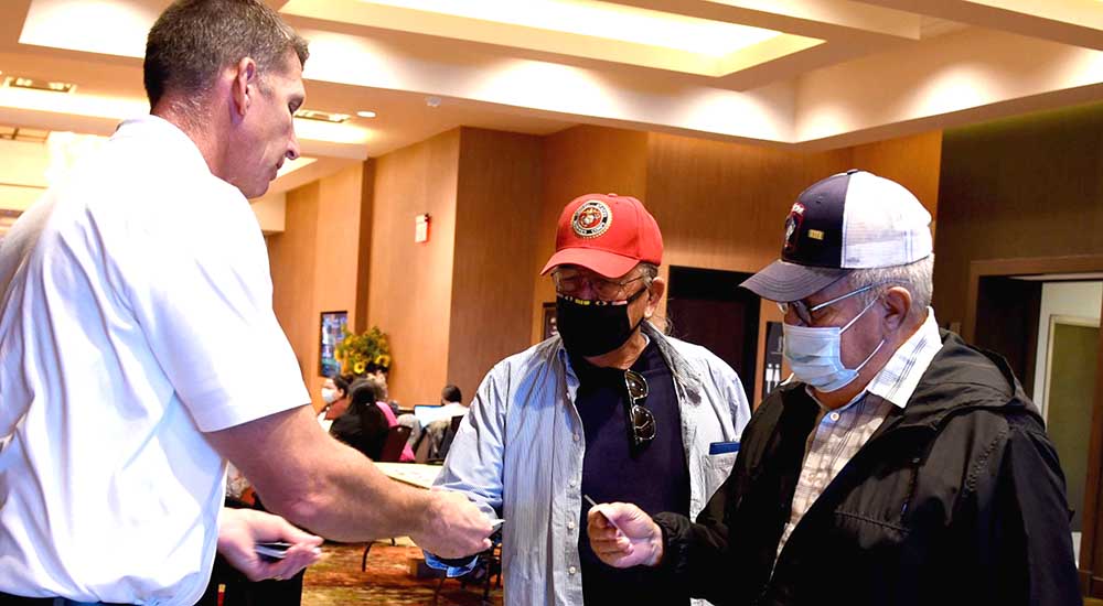 Man giving presumptive condition campaign information to two Veterans in Lawton, OK