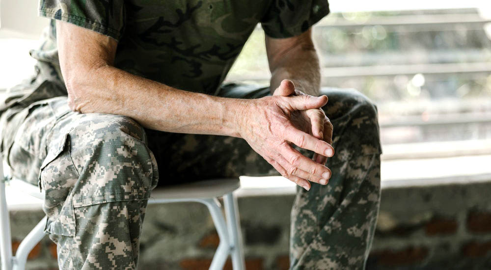 Folded hands of man in fatigues, sponsorship