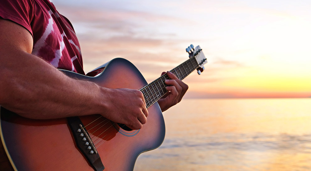 Man playing guitar on the beach