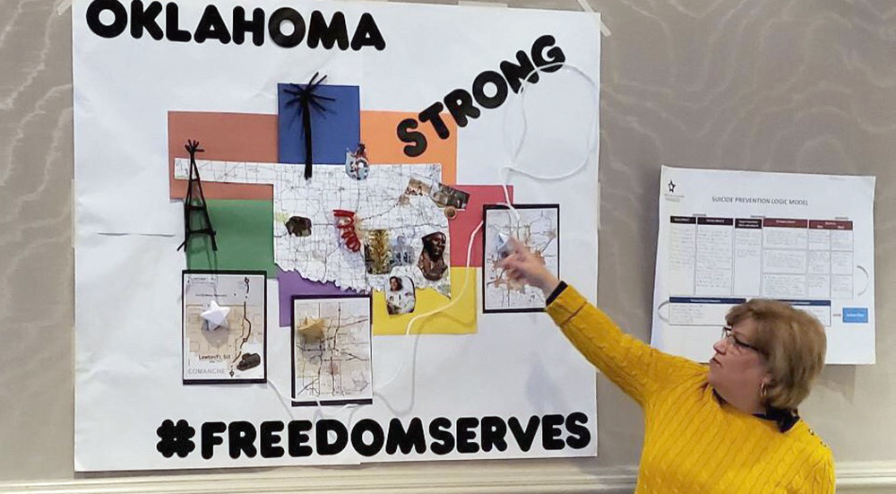 Woman placing pins in Oklahoma Strong poster