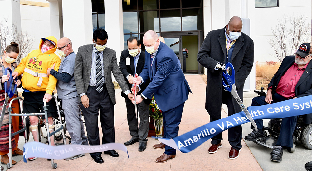 Eight people cut ribbon for new prosthetic and rehabilitation wing