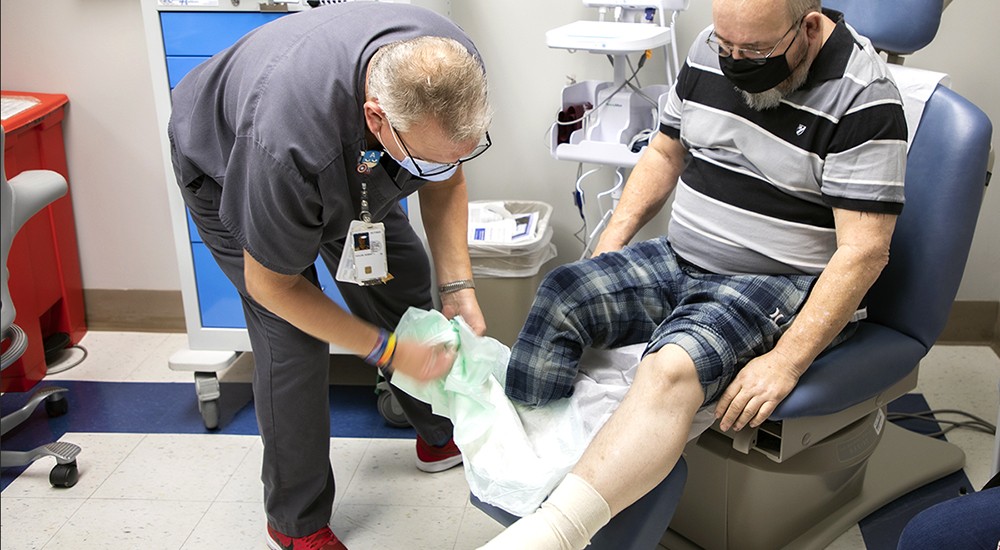Nurse examines Veteran’s foot, which was injured by diabetes