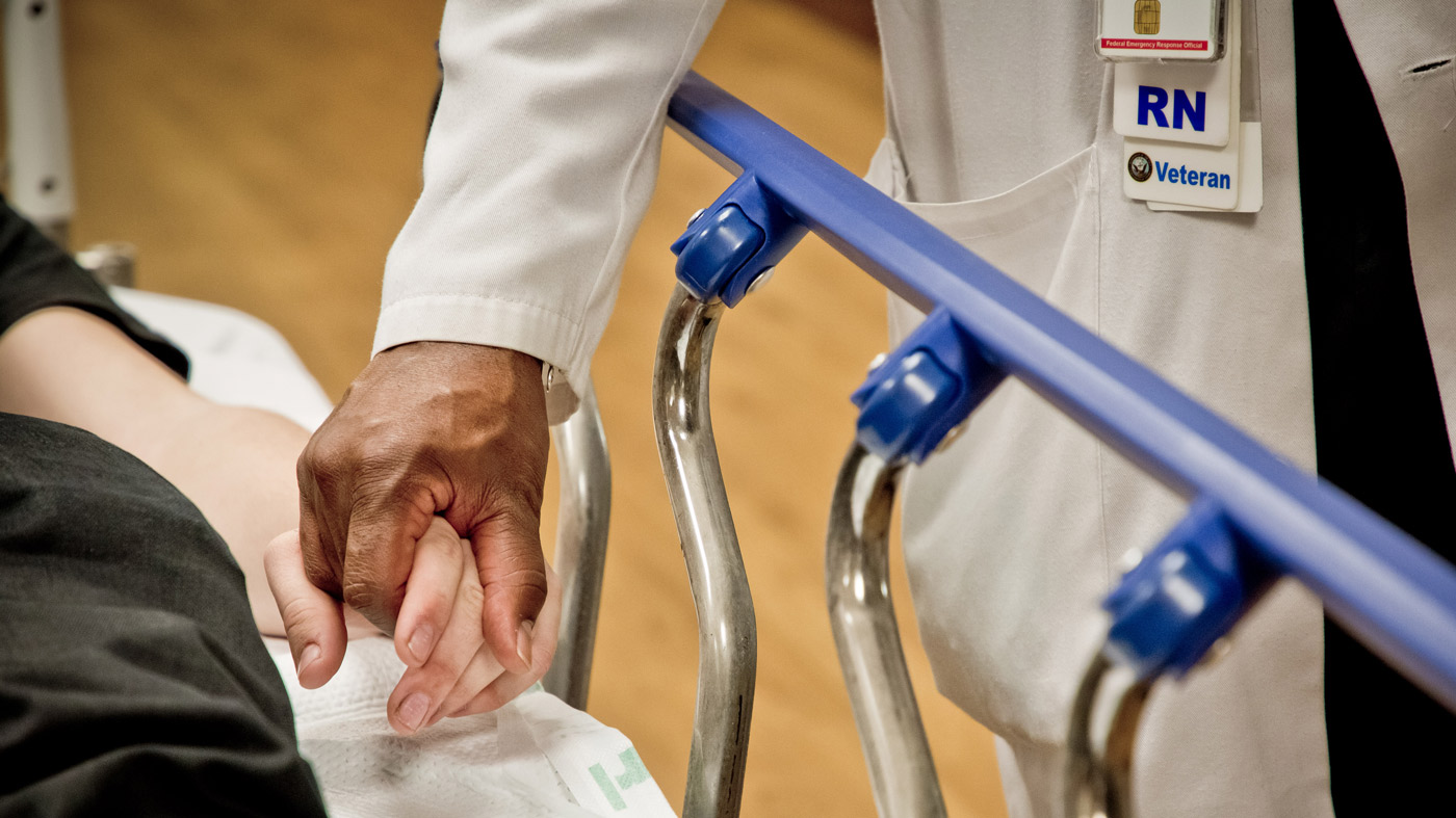 Health care worker holding patient's hand