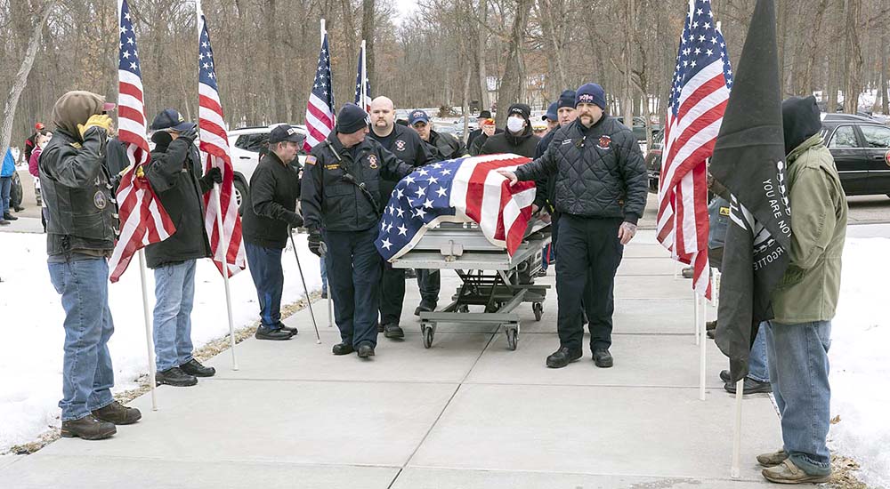 Pall bearers escort a Veteran’s casket at his funeral