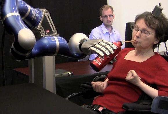 Paralyzed by a stroke, a Brain Gate participant uses her thoughts to control a robotic arm, grasp a bottle of coffee, serve herself a drink, and return the bottle to the table.