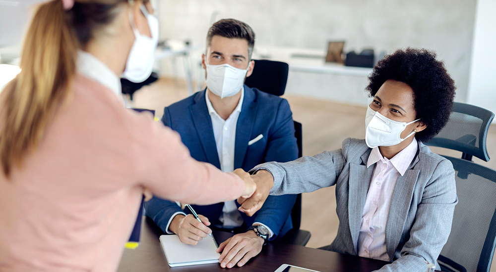 People congratulating woman for her new employment with fist bump