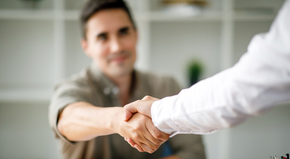 Two men shake hands