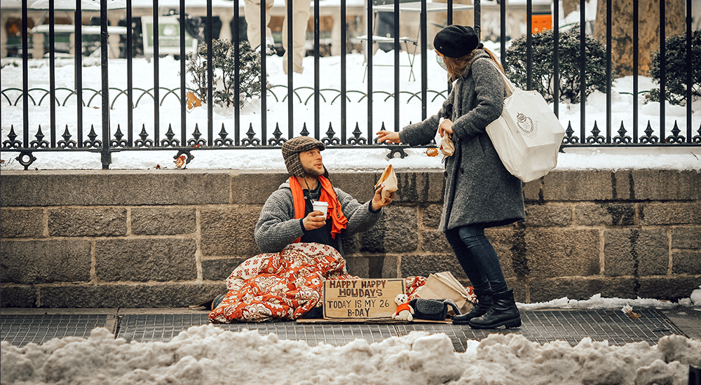 Woman offers homeless man food