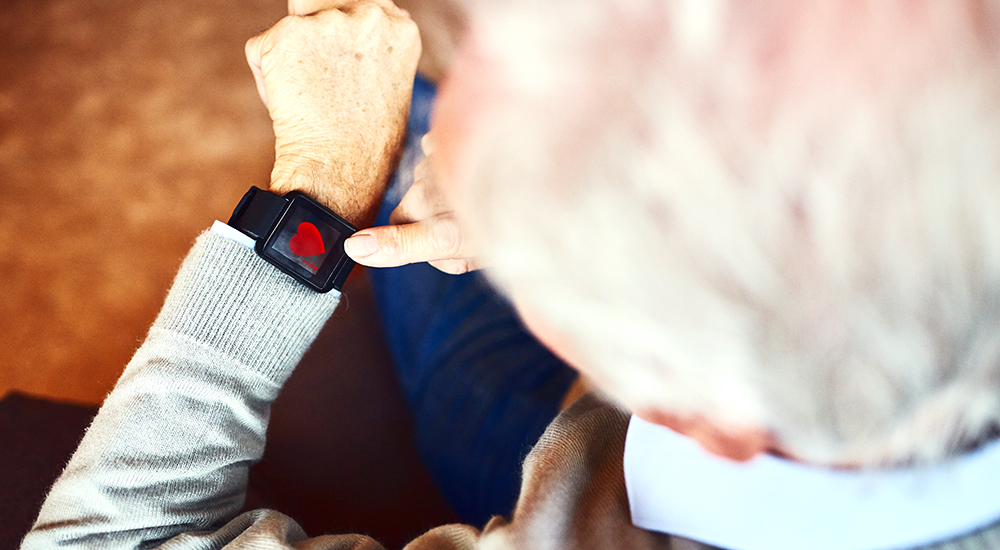 A man uses a smartwatch device for an electrocardiogram for heart health