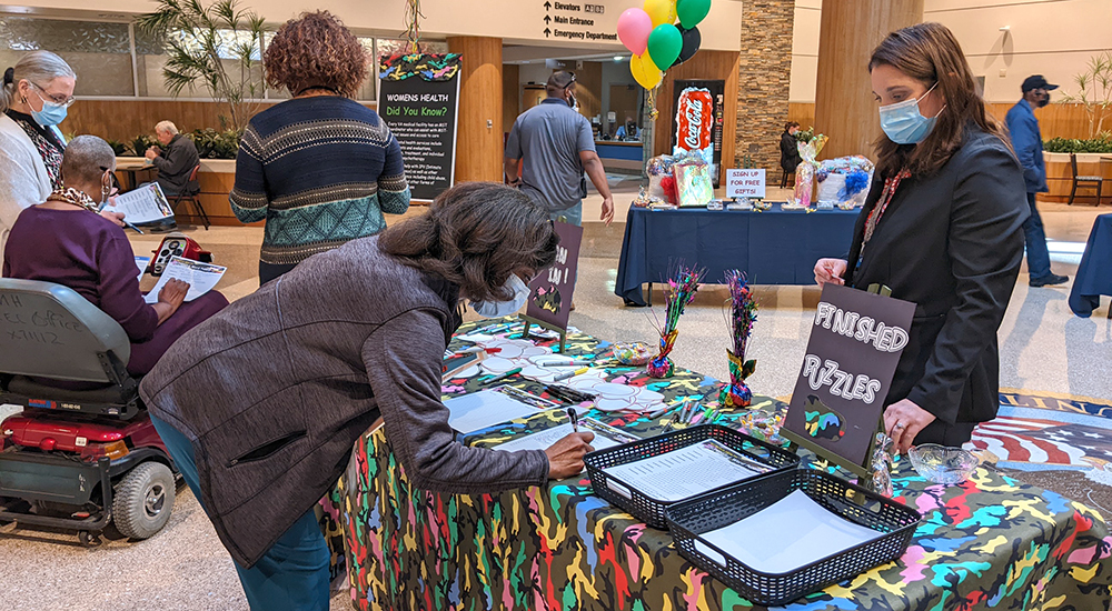 Woman signing form at fair table