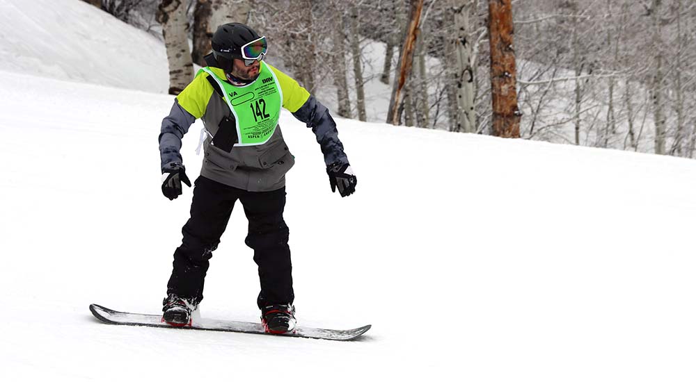 Veteran snowboarding down a mountain