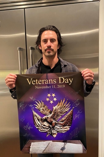 Man holding signed Veterans Day poster