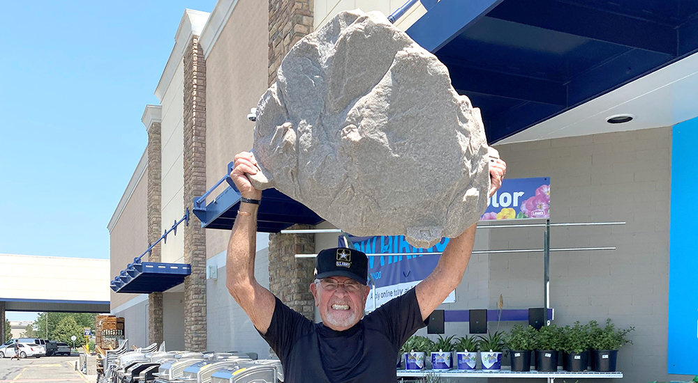 A stent recipient holds a decorative rock over his head