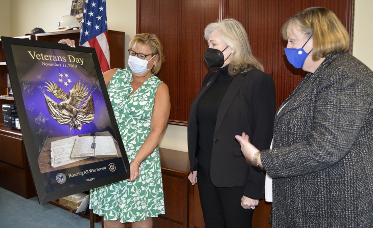 VA Bedford Healthcare System Director Joan Clifford presents the poster signed by the “This is US” cast to Teresa Harrington (center)