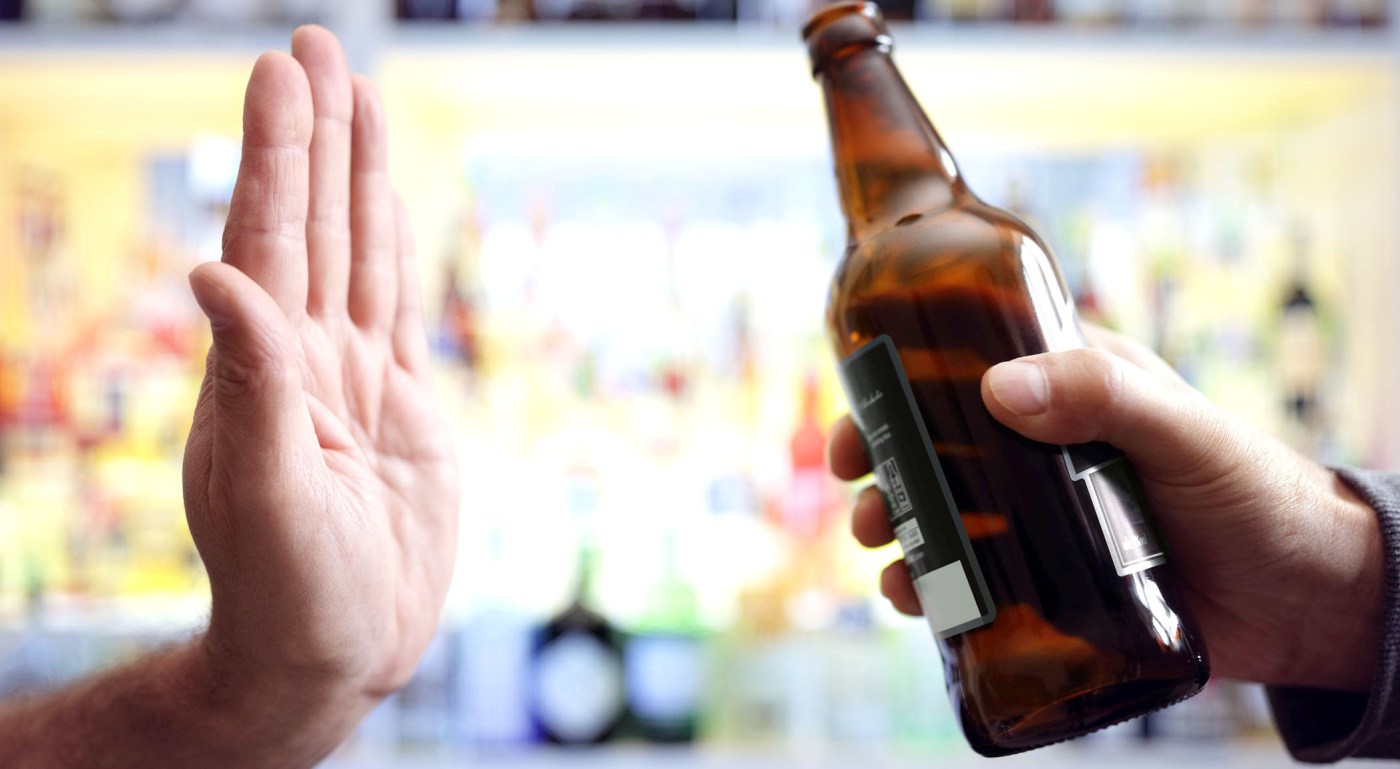 Hand rejecting bottle of alcohol