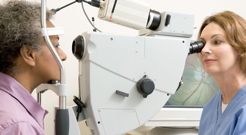 Optometrist conducting eye test on patient, TeleEye