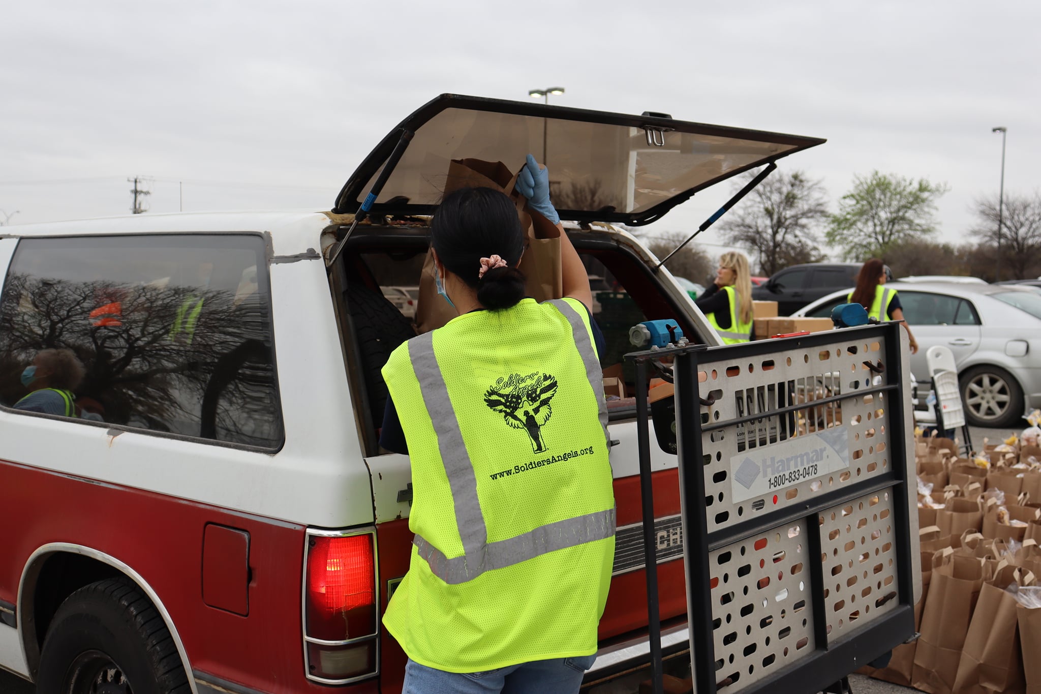 woman loading food into a truck duing Soldiers' Angels food assistance event
