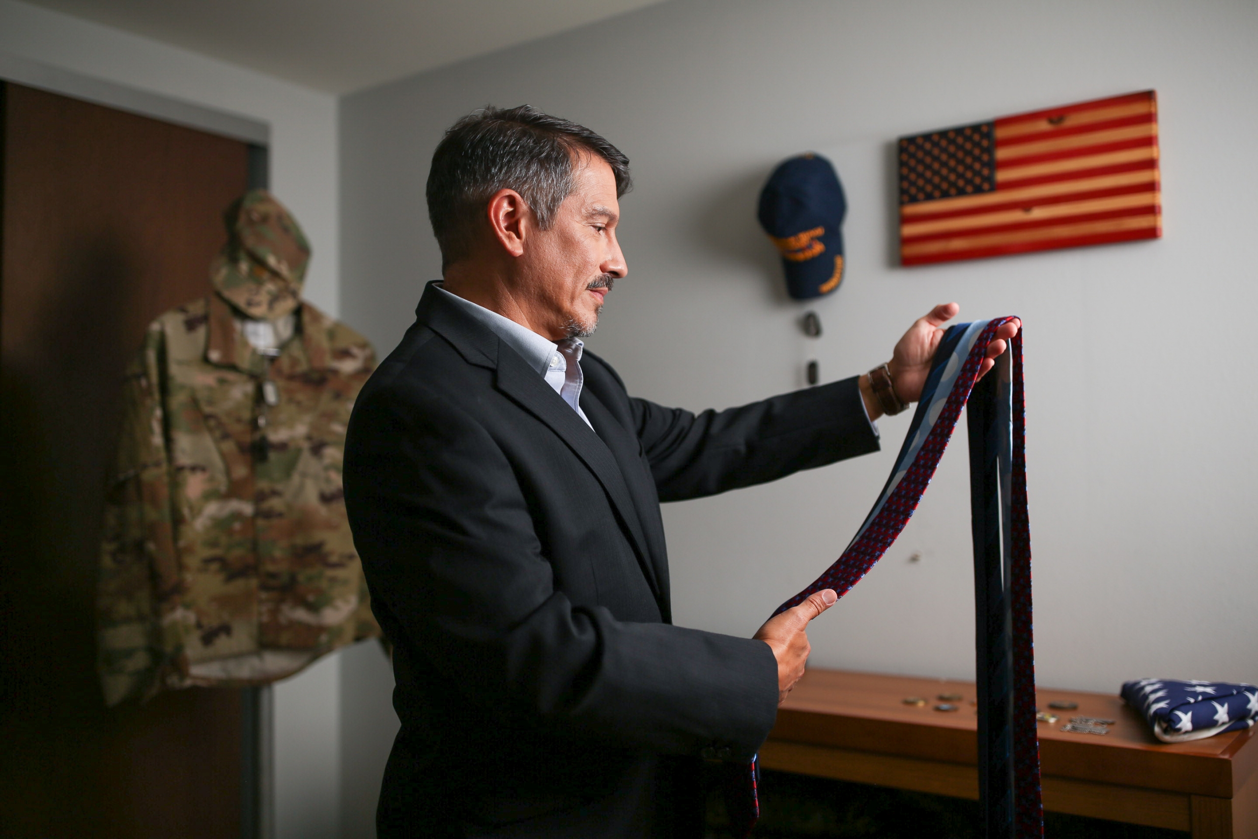 man putting on tie for veteran readiness and employment career fair