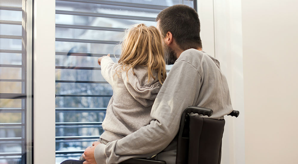 Man with spinal cord injury in wheelchair with daughter