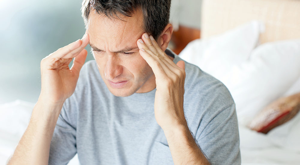 Man with headache holding his head