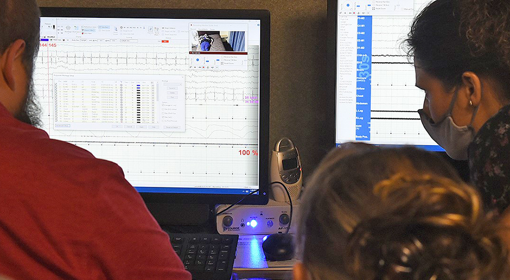 Two technicians monitor sleep apnea study screens