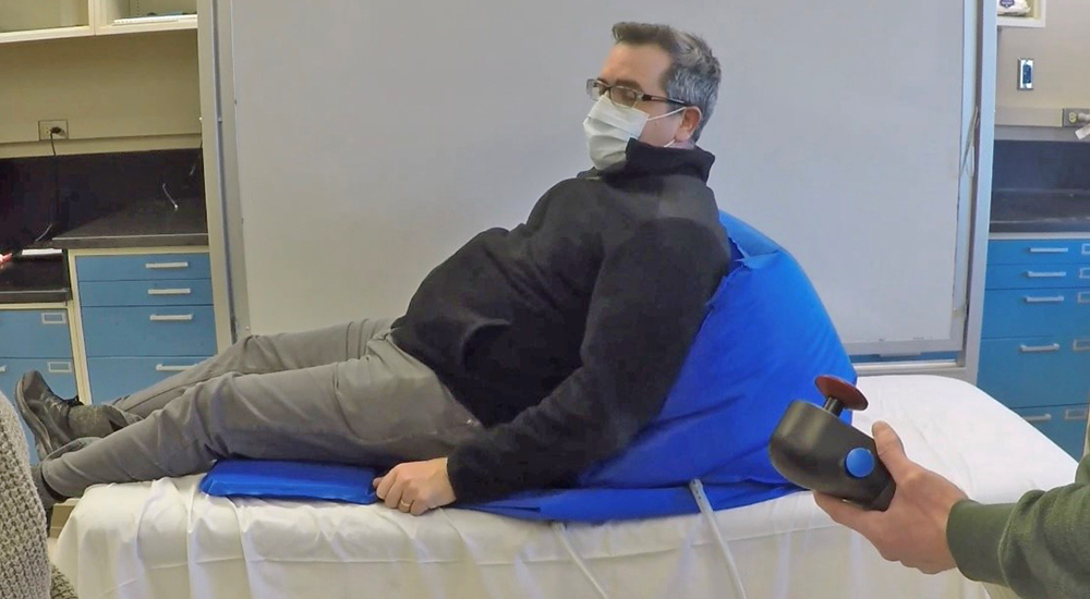 Kyphotic Veteran patient sits on inflatable wedge