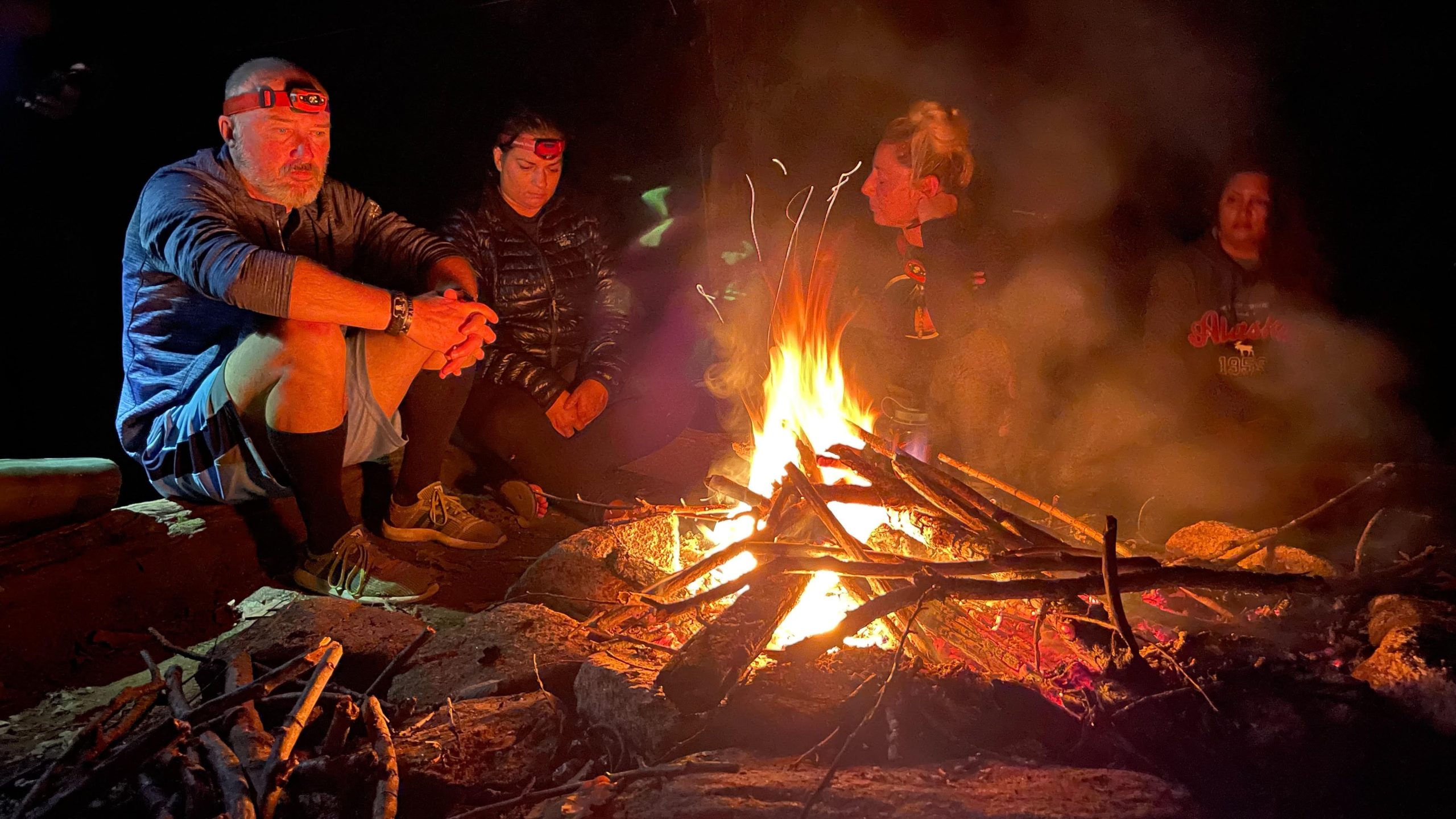 people sitting around campfire during hiking expedition