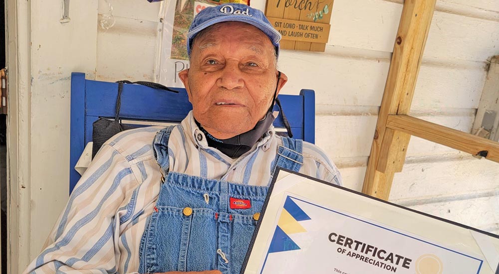 Senior Veteran “Sugar Boy” McCain holding certificate of appreciation