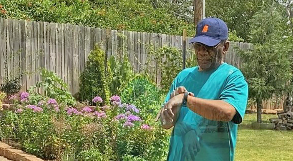 Man in cap adjusting fitbit on his wrist