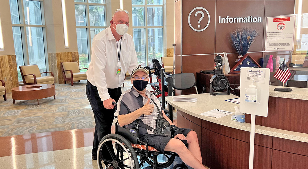 Patient ambassador pushing a Veteran patient in a wheelchair