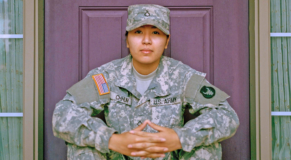 Woman in uniform sitting on door stoop; Women's Equality Day