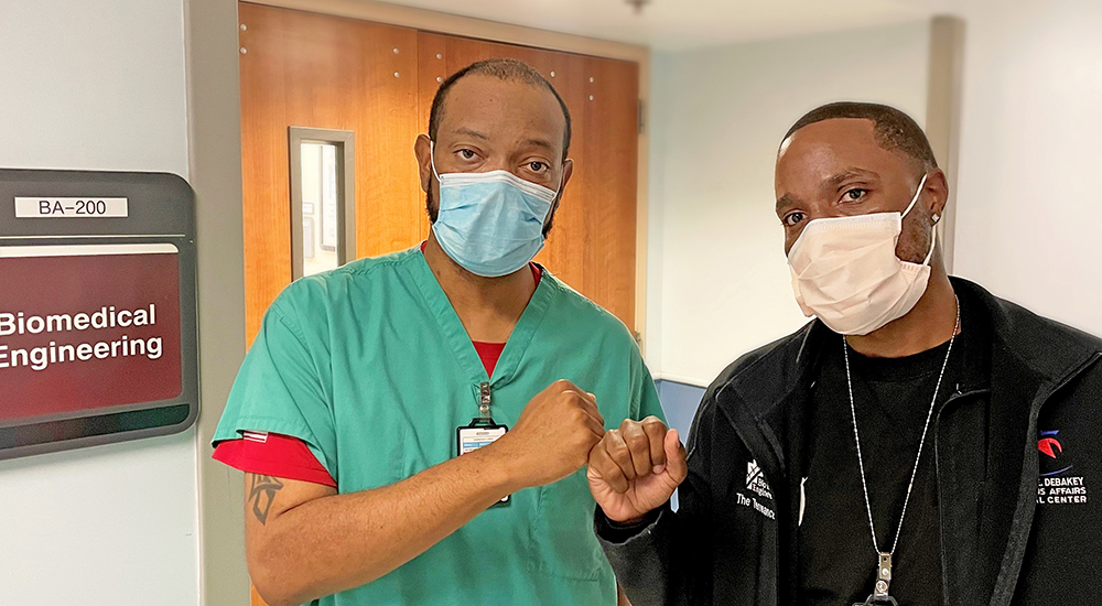 Two VA employees fist bump; kidney donation