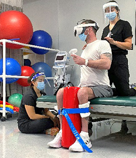 Two therapists help patient with virtual reality exercise